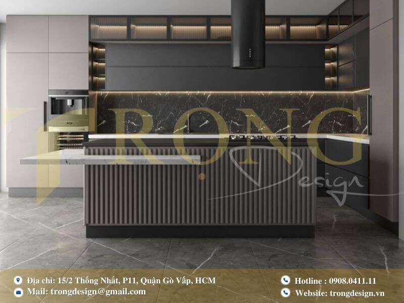 Bếp hiện đại tông xám trầm với đảo bếp liền bàn ăn và tủ kính trưng bày có đèn.