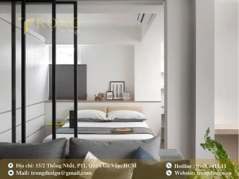 Phòng ngủ khách tối giản với vách ngăn kính linh hoạt và nội thất gọn gàng.
