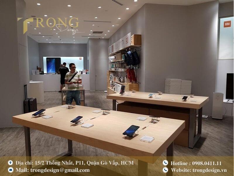 Thiết kế cửa hàng Apple mẫu, tối giản, sử dụng bàn gỗ và sàn trắng.