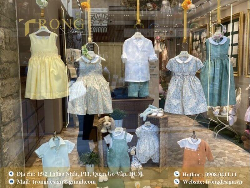 Cửa sổ trưng bày cửa hàng thời trang trẻ em cao cấp, với các thiết kế tinh xảo.